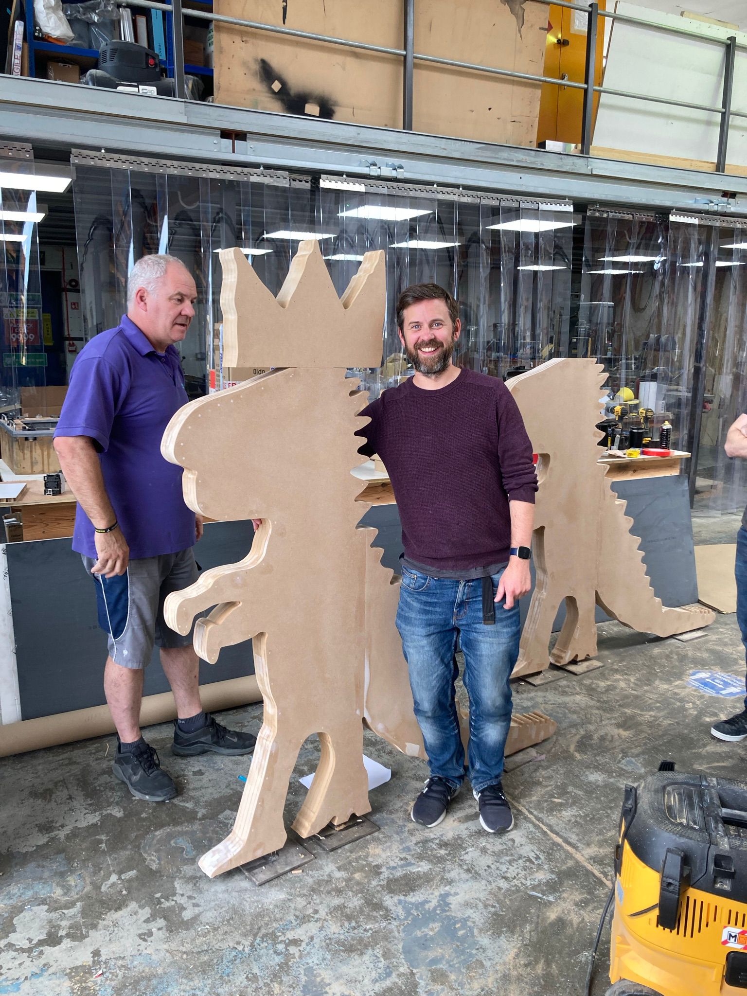 Workshop shot showing large CNC-cut MDF character shapes in a fabrication shop with staff and tools; illustrating our CNC and fabrication capability.