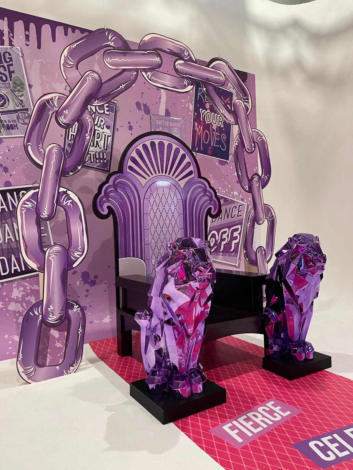 Purple-themed event photo set featuring a printed backdrop, throne prop and two faceted lion sculptures on printed floor vinyl, ideal for experiential activations and brand photography.
