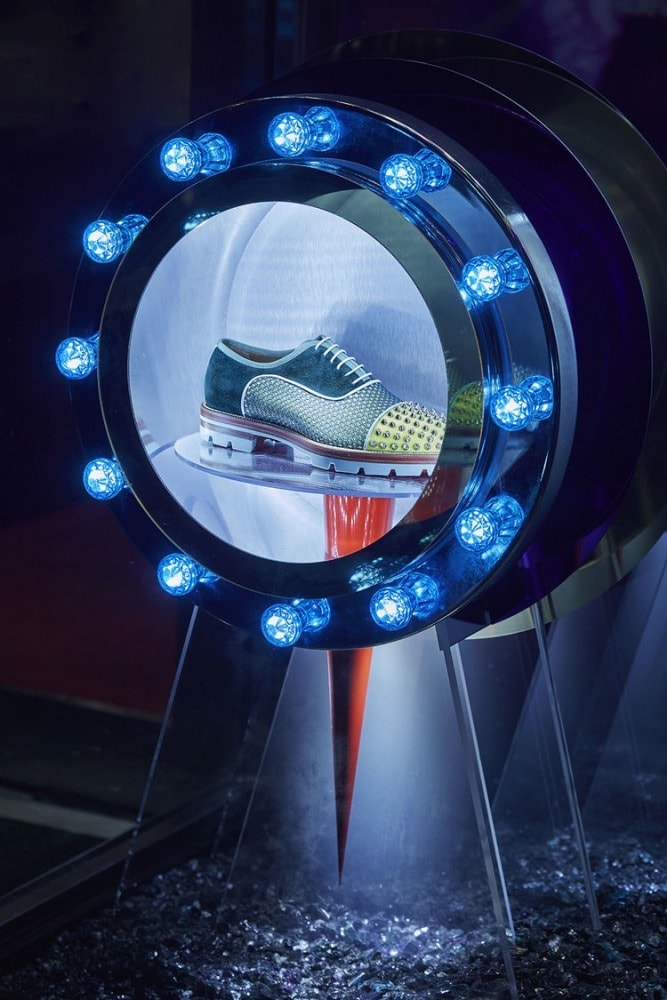 Illuminated acrylic shoe display in retail window setting.